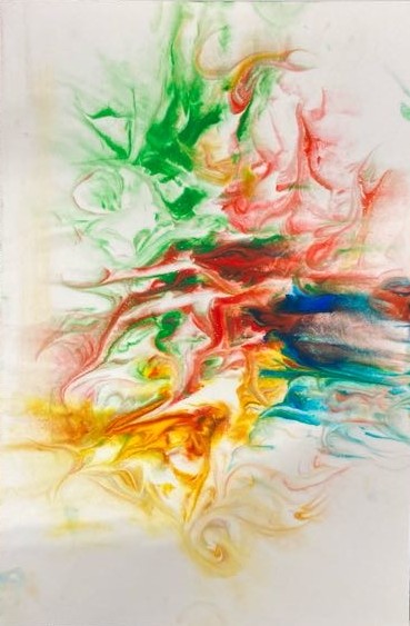  A close-up shot of an abstract artwork featuring swirling greens, reds, blues, and yellows on medium-sized photo paper. The colors are denser and mixed more in the center and fade as they approach the edges of the photo paper. The artwork rests on a black fabric background. 